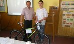 Zástupca školy Ing. Jančo odovzdáva Ivanovi Kuchtovi výhernú  cenu bicykel